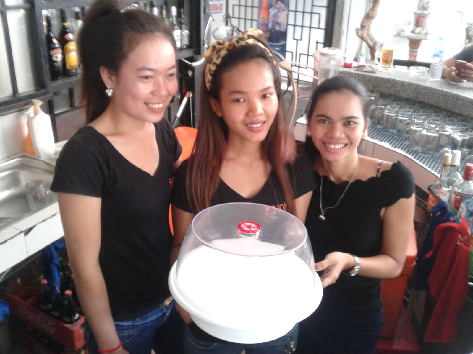 3 women, Equinox staff, hold an empty display dish.